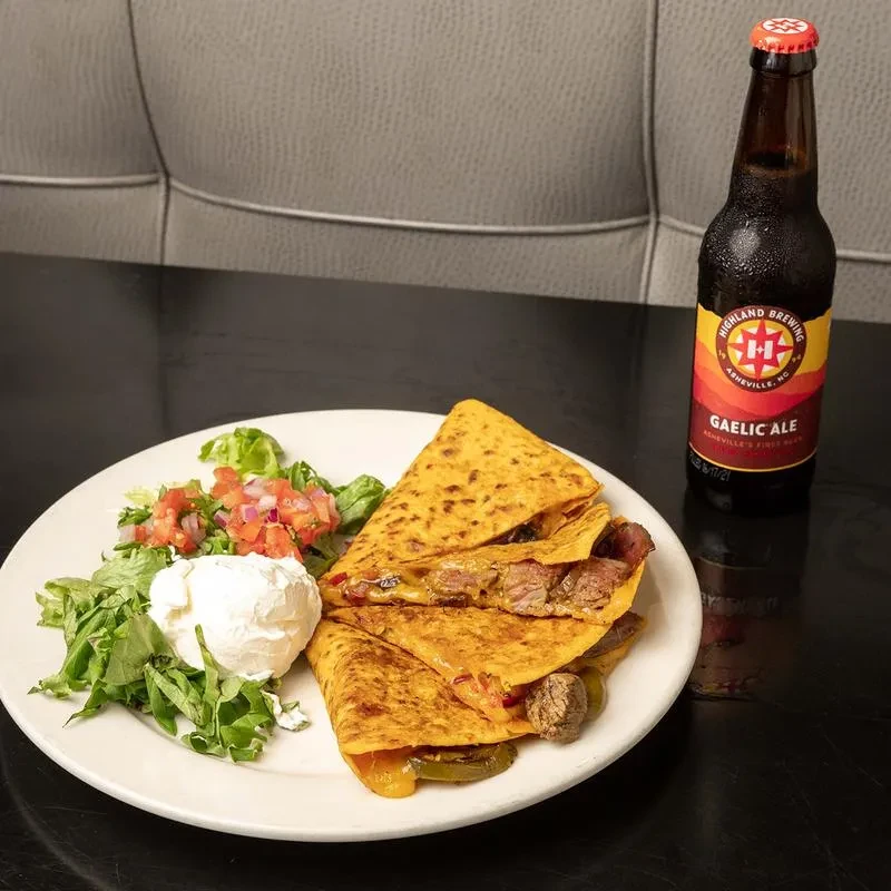 Steak quesadilla, side salad, and a bottle of Gaelic Ale beer.