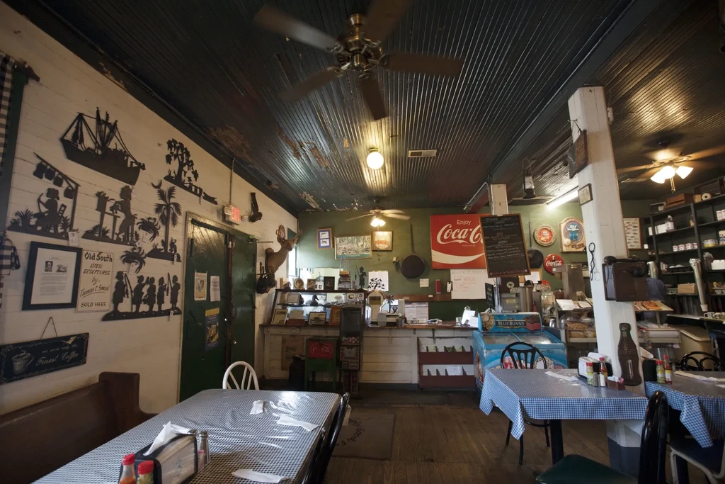 Empty, rustic diner interior with checkered tables and eclectic Southern decor.