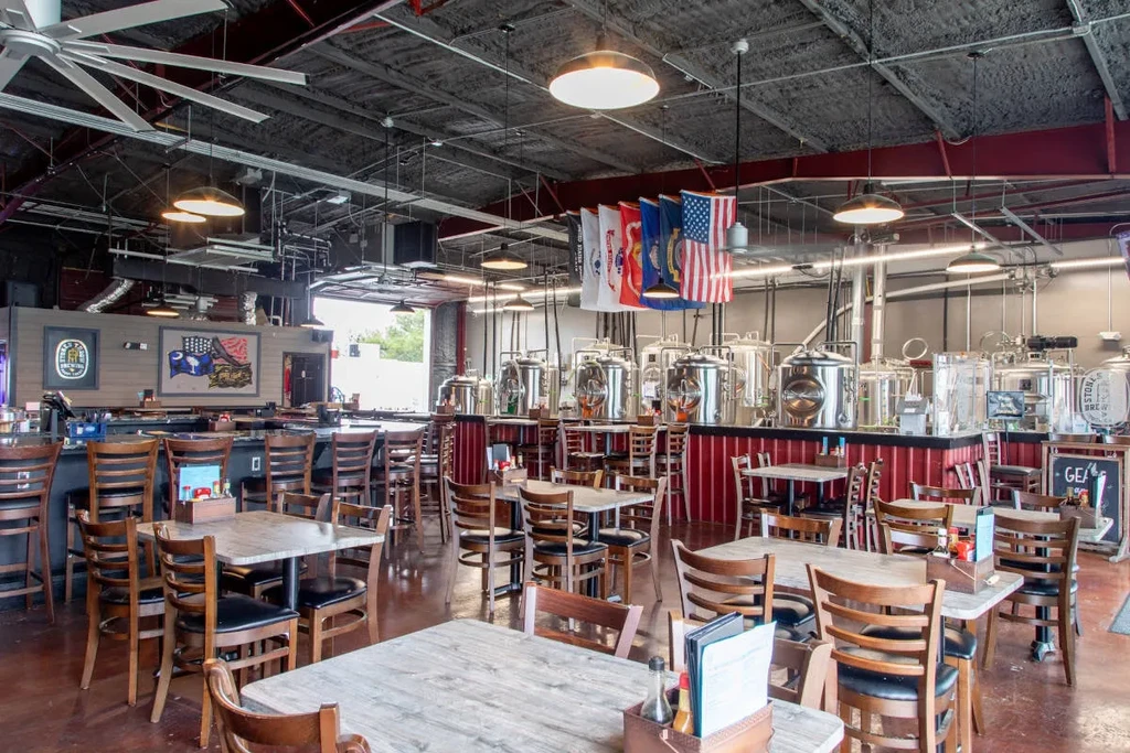 Empty, spacious brewpub with bar, dining, and brewing tanks.