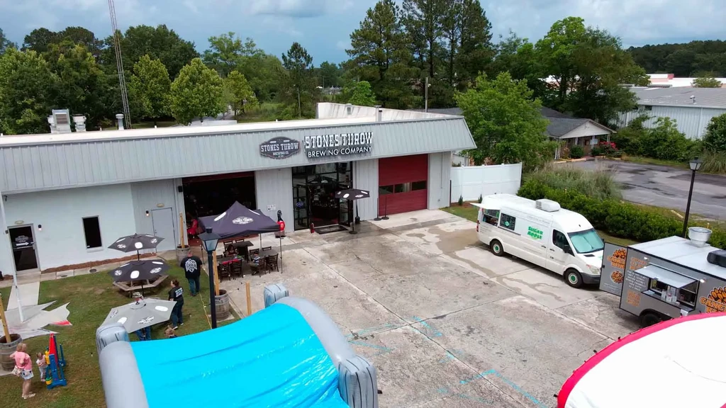 Aerial: Stones Throw Brewing, outdoor seating, food trucks, and play area.