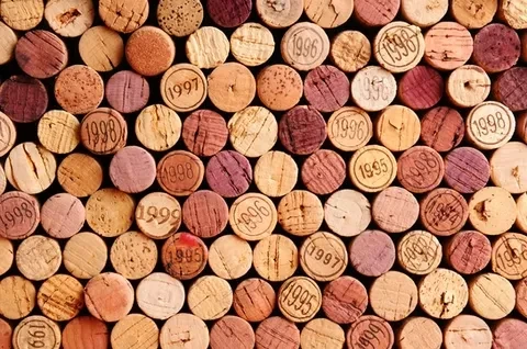 Rows of tightly packed natural wine corks displaying various stamped years.