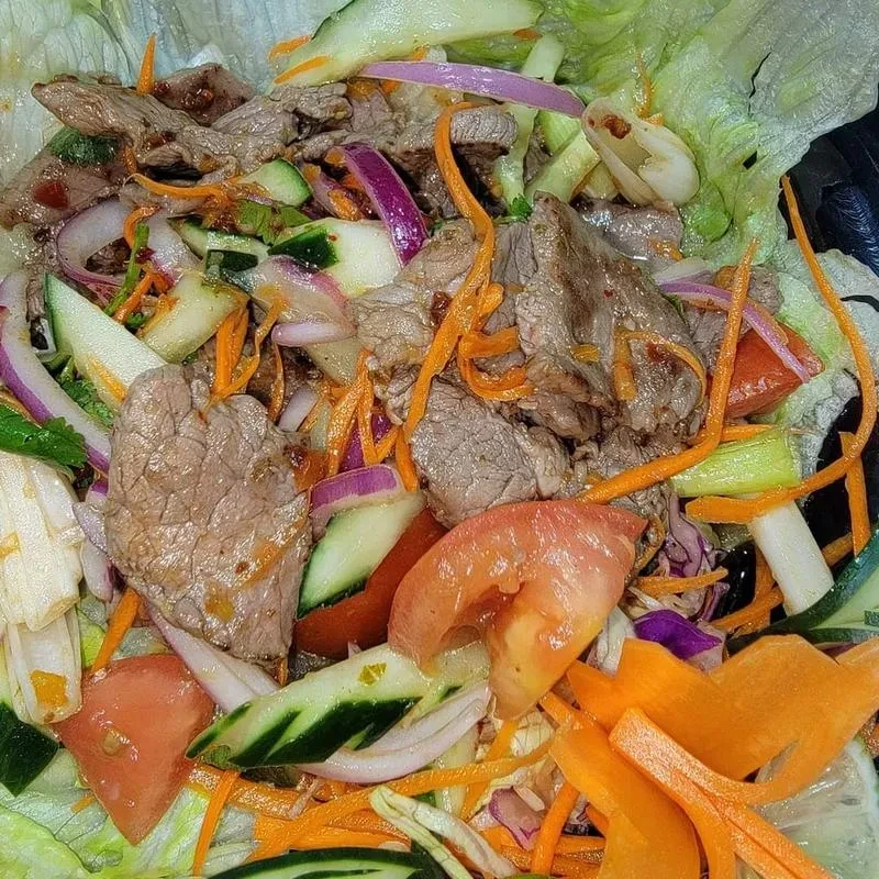 Vibrant beef salad with sliced beef, lettuce, and fresh vegetables.
