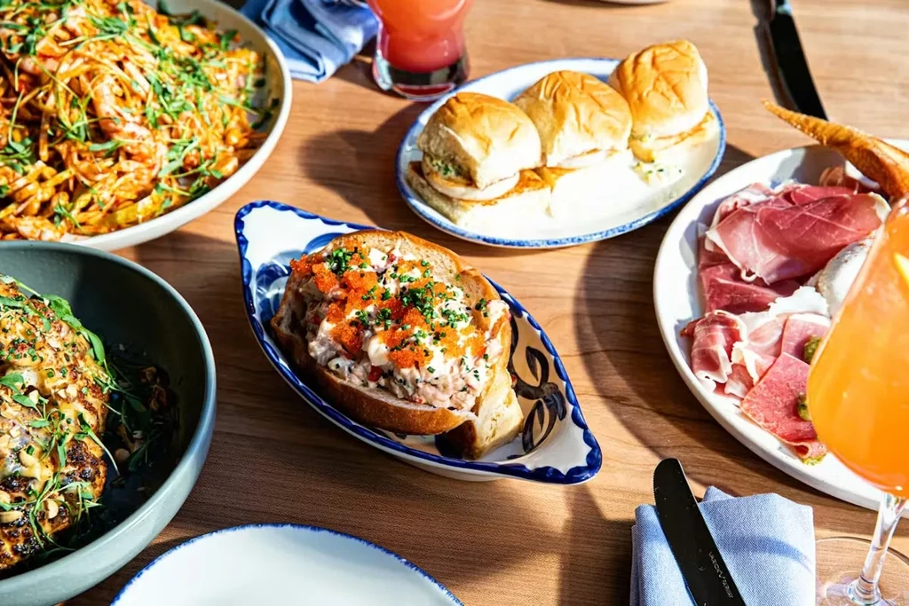 Overhead photo of a wooden table with varied dishes and drinks.