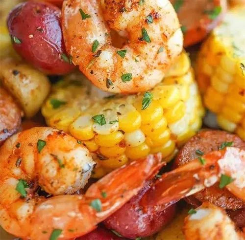 Vibrant close-up of seasoned shrimp, corn, potatoes, and sausage.