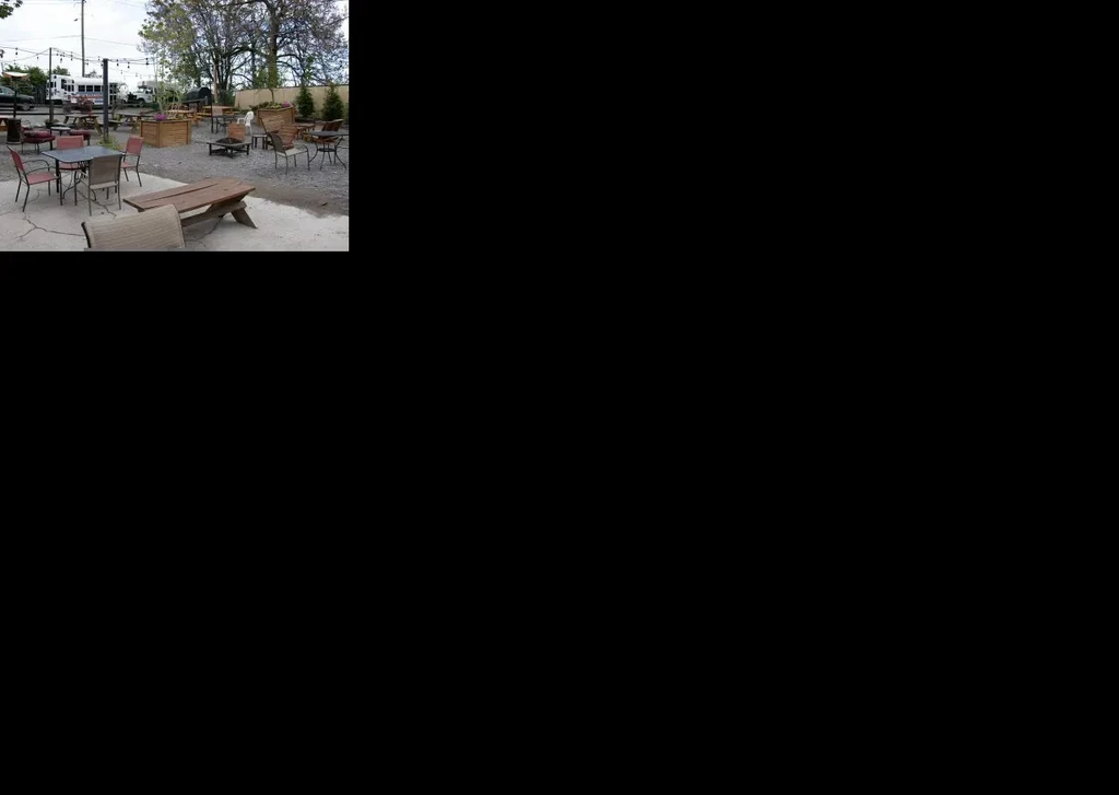 Outdoor patio with various seating, string lights, and trees.