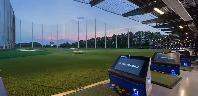 Topgolf driving range at dusk with empty bays and targets.