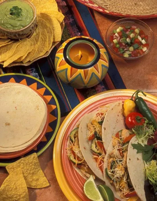 Vibrant Mexican food spread with tacos, guacamole, chips, and salsa.