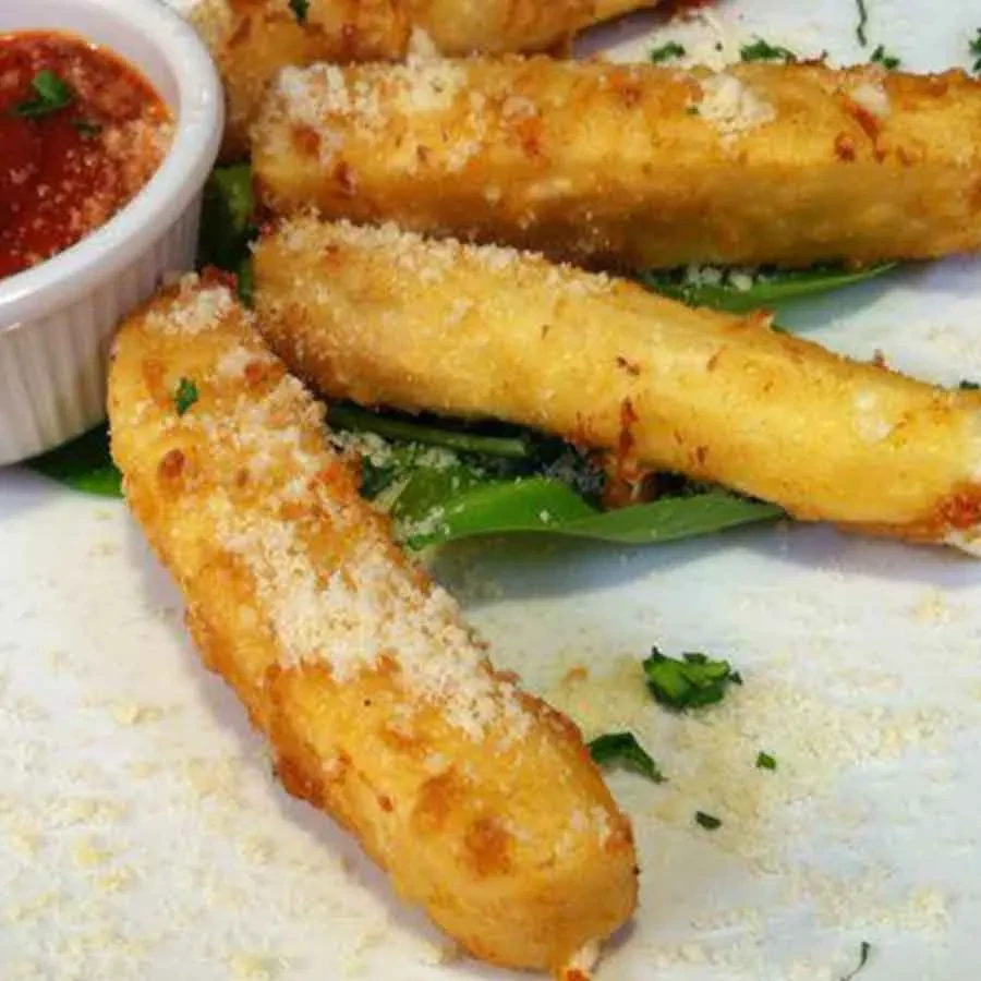 Fried cheese sticks with Parmesan, green herbs, marinara, and leafy greens.