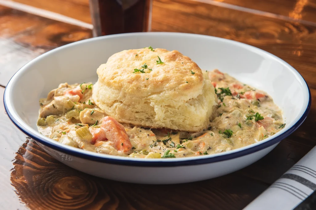 Golden biscuit on creamy chicken stew with vegetables and herbs.