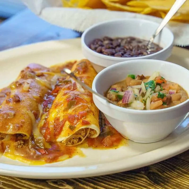 Three enchiladas, red sauce, melted cheese, black beans, pinto beans, chips.