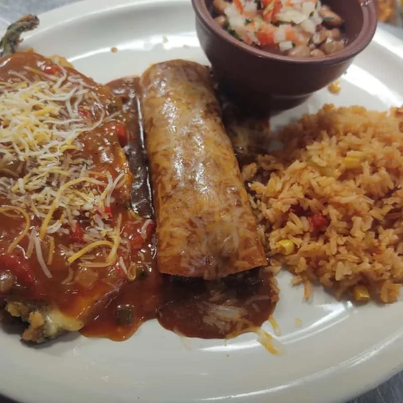 Mexican food plate with chili relleno, enchilada, rice, and refried beans.