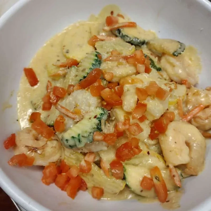 Creamy shrimp dish with zucchini and diced tomatoes.