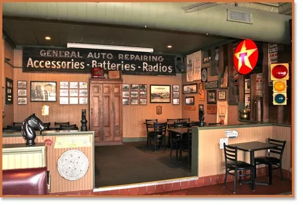 Rustic restaurant interior with automotive signs, Texaco logo, and traffic light.