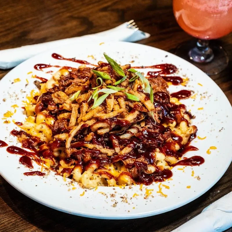 Mac and cheese with BBQ pulled pork, crispy fried onions, and green onions.