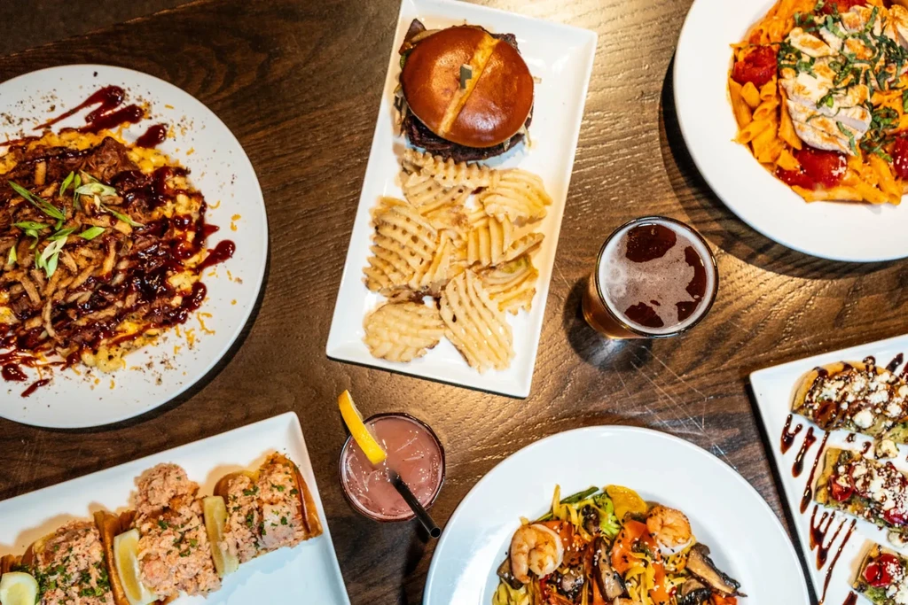 Overhead view of a table laden with diverse food plates and drinks.