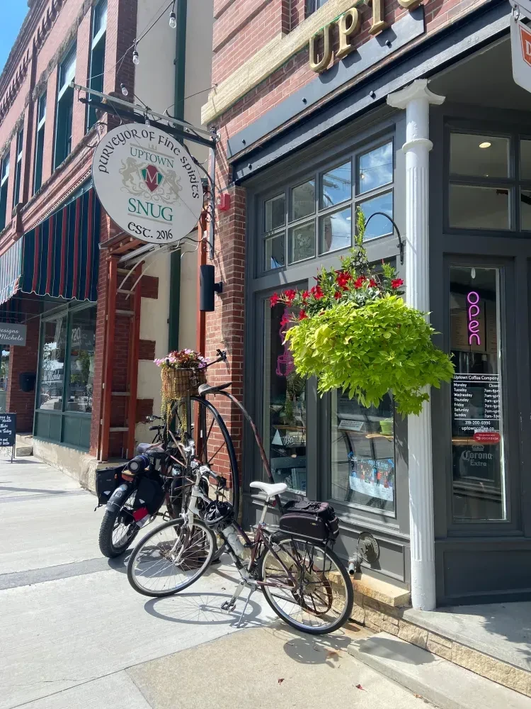 Brick storefront of Uptown Snug and Coffee with a penny-farthing bicycle.