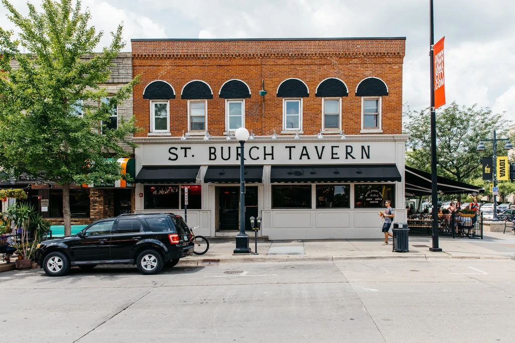 Exterior of brick ST. BURCH TAVERN on a lively downtown street.