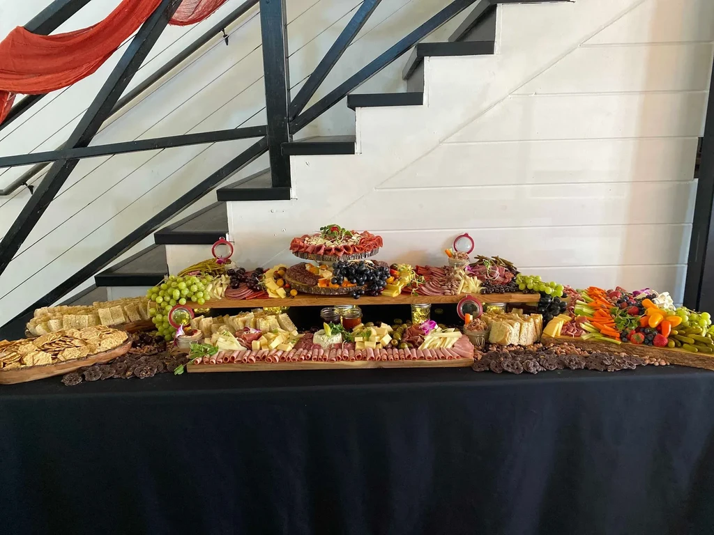Elaborate charcuterie buffet with cheeses, meats, fruits, and snacks.