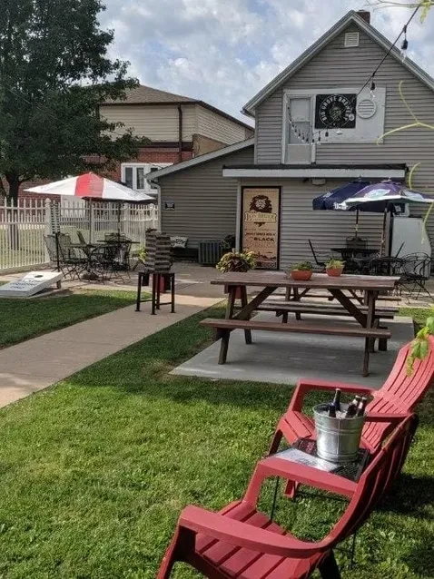 Big Grove Brewery's outdoor patio with seating, beer, and cornhole.