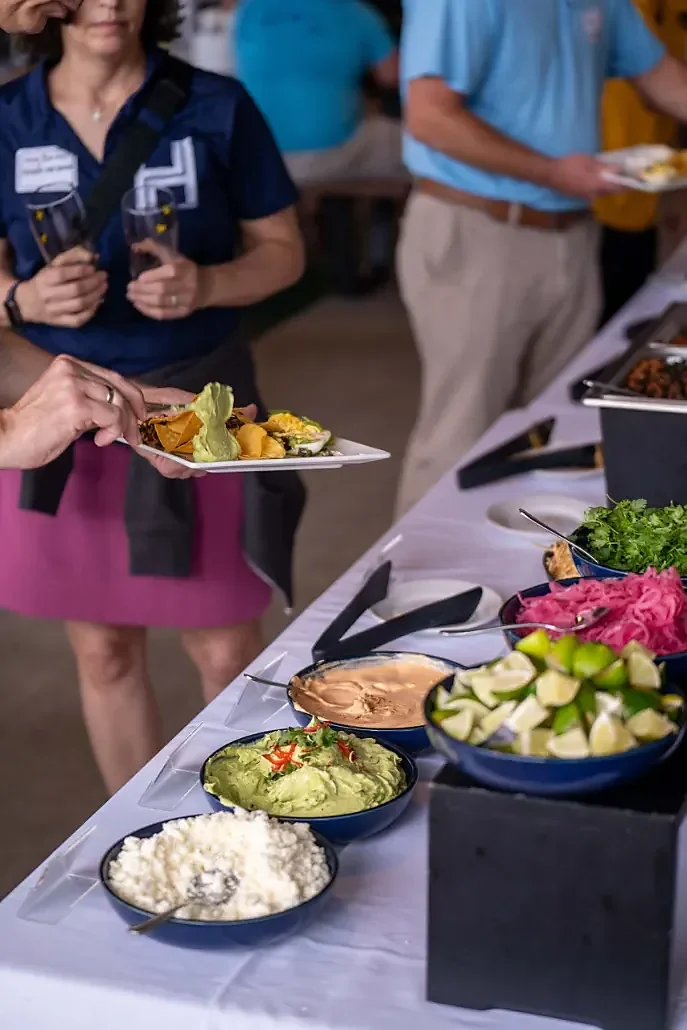 Taco bar spread with guacamole, limes, pickled onions and cotija cheese