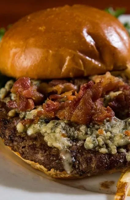 Gourmet burger with brioche bun, melted blue cheese, and crispy bacon.