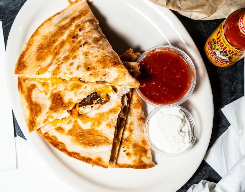 Crispy quesadilla wedges with cheese, salsa, sour cream, and Cholula.