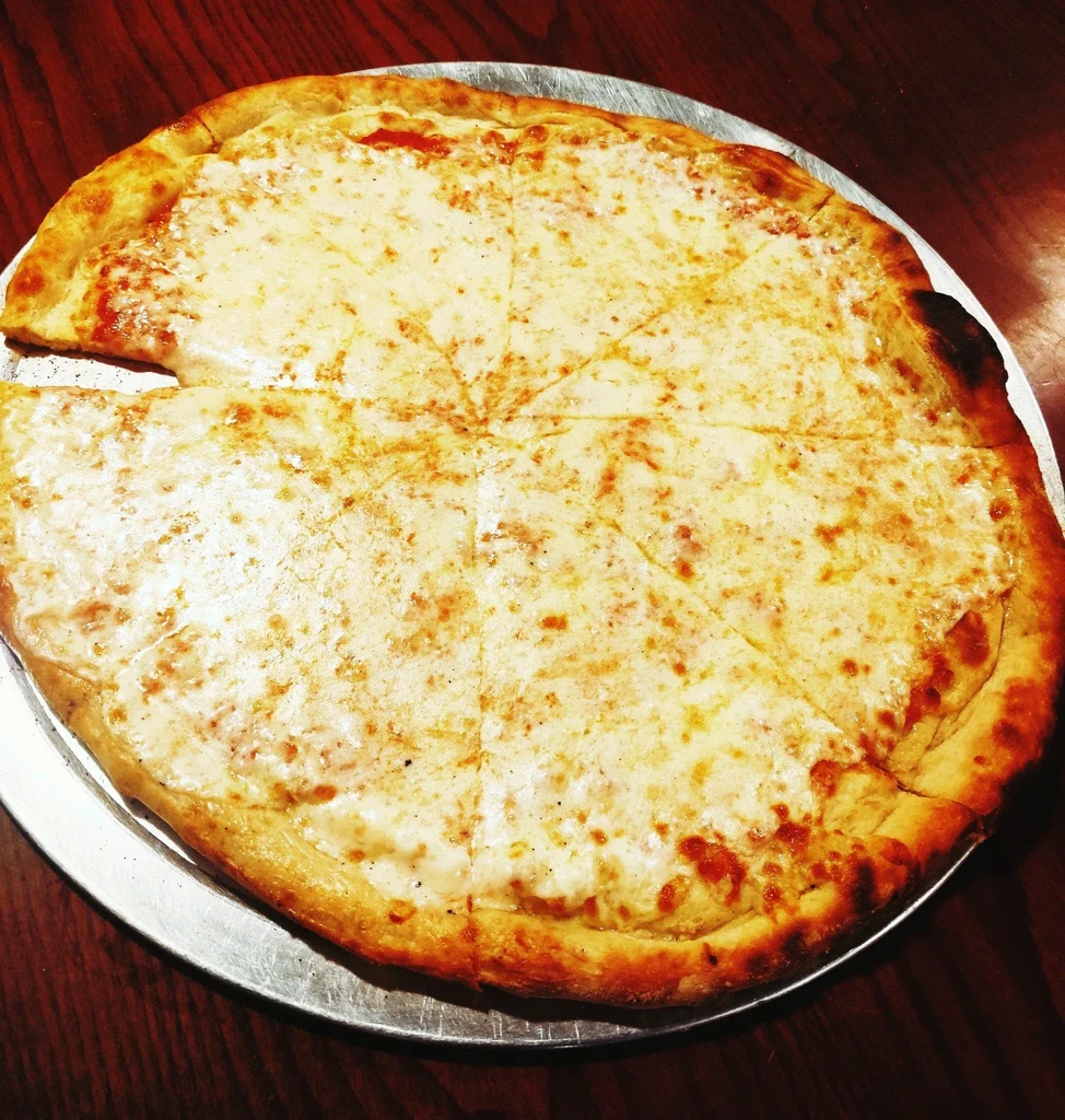 Round cheese pizza, one slice removed, on a metal pan.