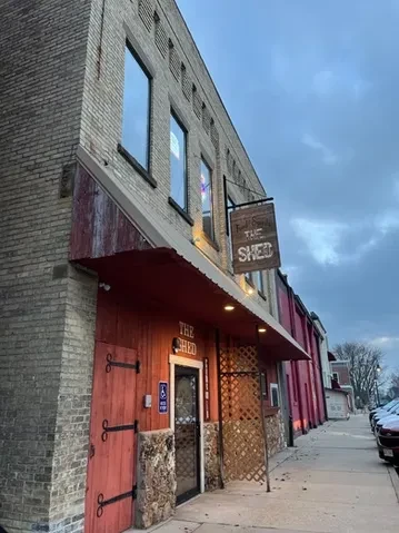 The Shed restaurant exterior, two stories of brick, wood, and barn doors.