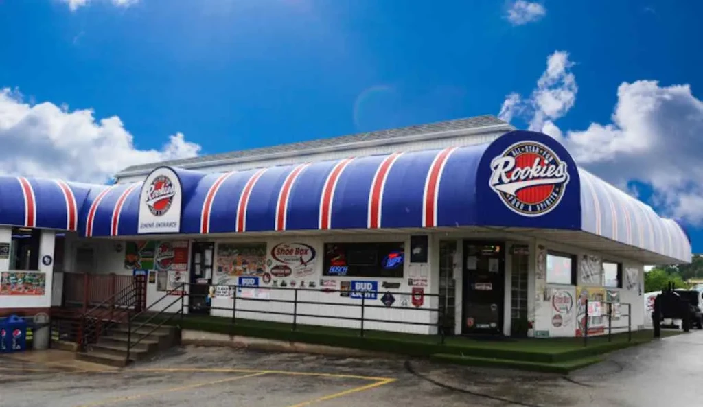 Rookies building exterior with blue/red striped awning under a bright sky.