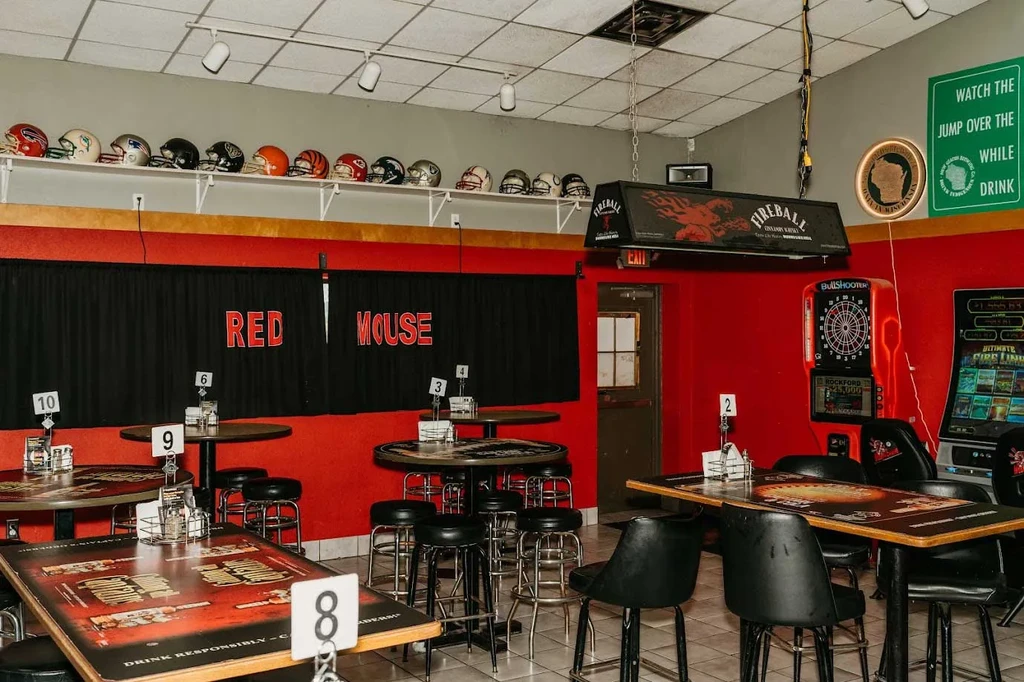 Red-walled sports bar interior with NFL helmets and arcade games.