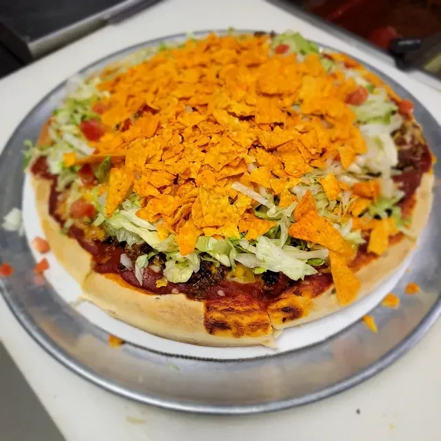 Deep-dish taco salad topped with bright orange crushed tortilla chips.
