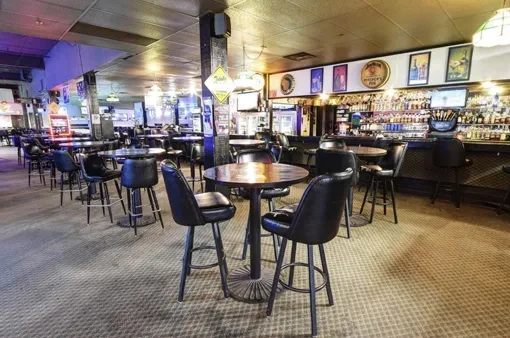 Empty Jameson's Pub interior with high-top tables and a well-stocked bar.