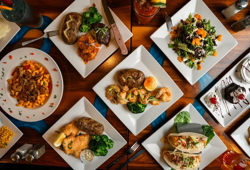 Overhead shot of varied dishes and drinks on a blue-accented table.