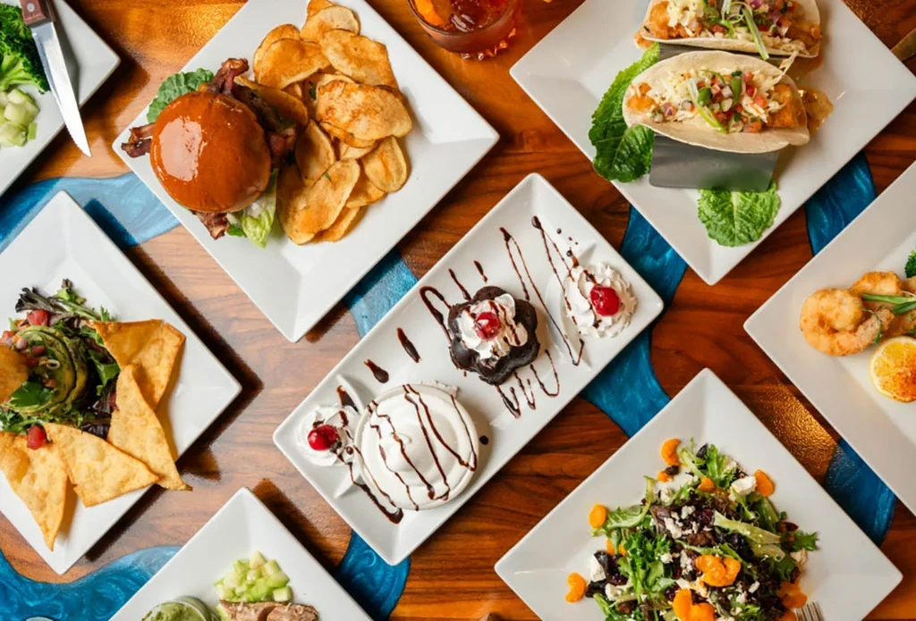 Overhead shot of diverse dishes on a blue resin inlay wooden table.