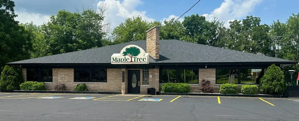 Maple Tree restaurant exterior: stone facade, large windows, green sign.