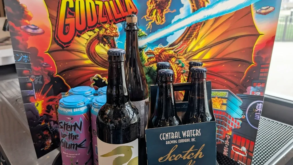 Beers in bottles and cans against a vibrant Godzilla display.