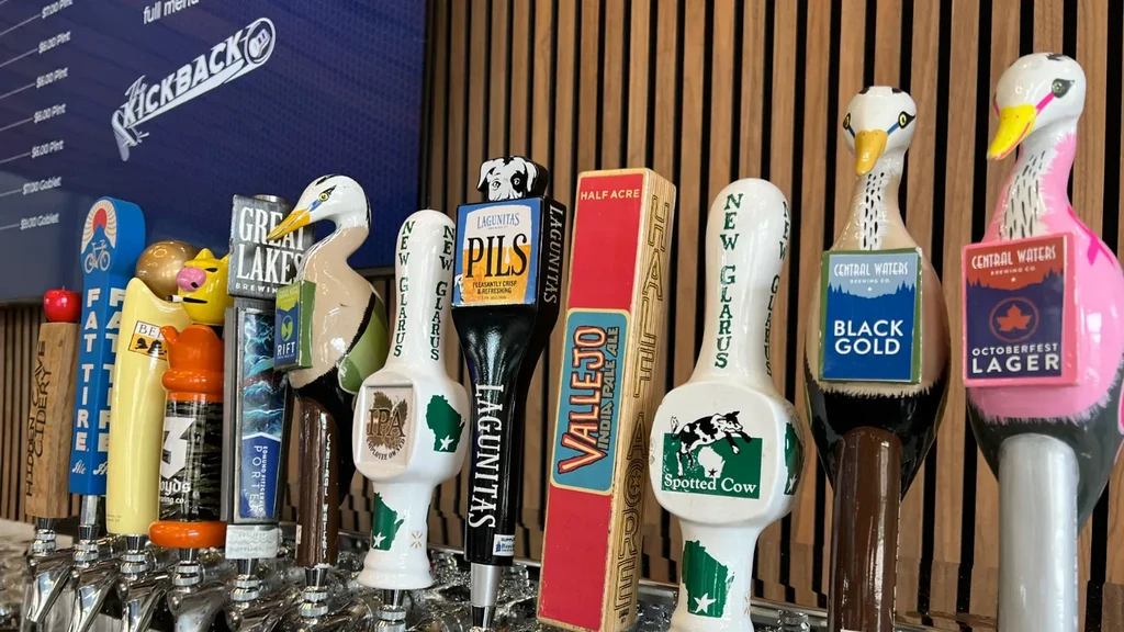Diverse branded beer tap handles line a bar at Kickback.
