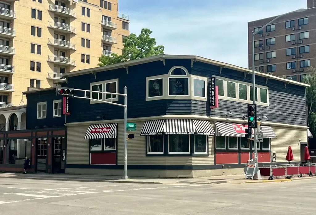 The Nitty Gritty restaurant with striped awnings on an urban corner.