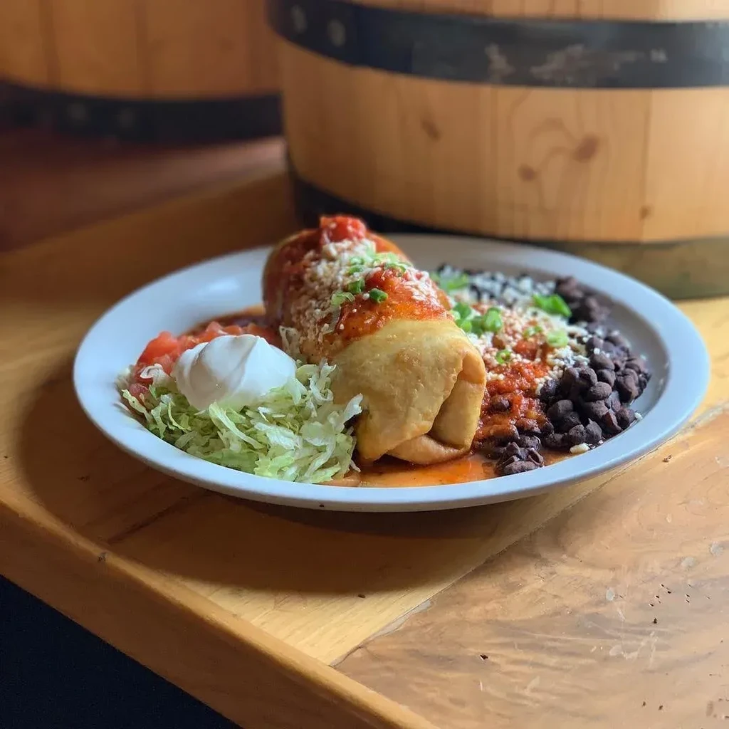 Fried chimichanga with salsa, cheese, lettuce, tomatoes, black beans.