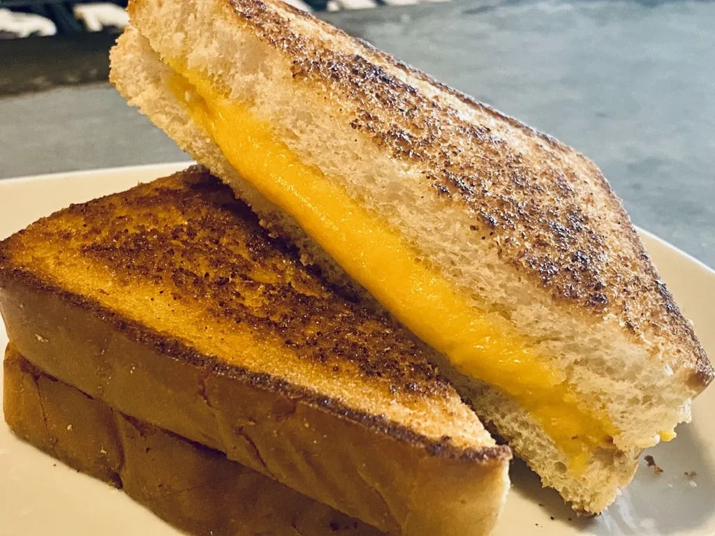 Crispy golden-brown grilled cheese halves with oozing melted cheese.