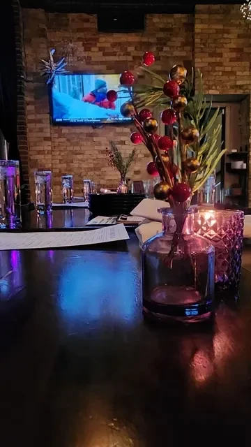 Restaurant table with centerpiece, lit candle, and TV showing snow sports.