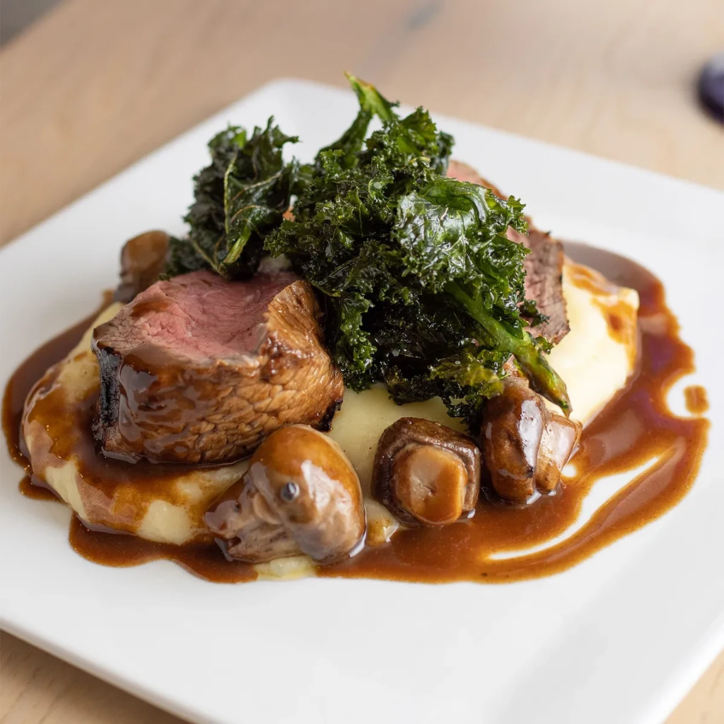 Medium-rare beef, kale, mashed potatoes, mushrooms, and dark gravy.