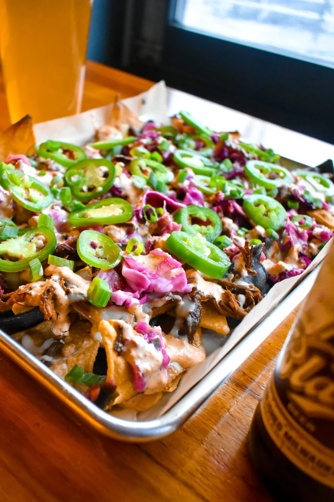 Nachos with shredded meat, jalapeños, green onions, and beer.
