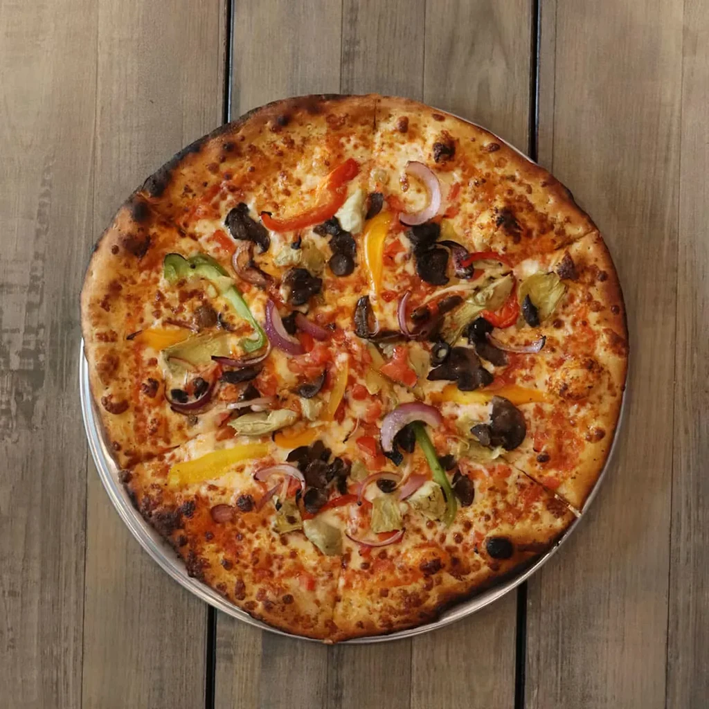 Freshly baked pizza topped with cheese and colorful vegetables, on wood.