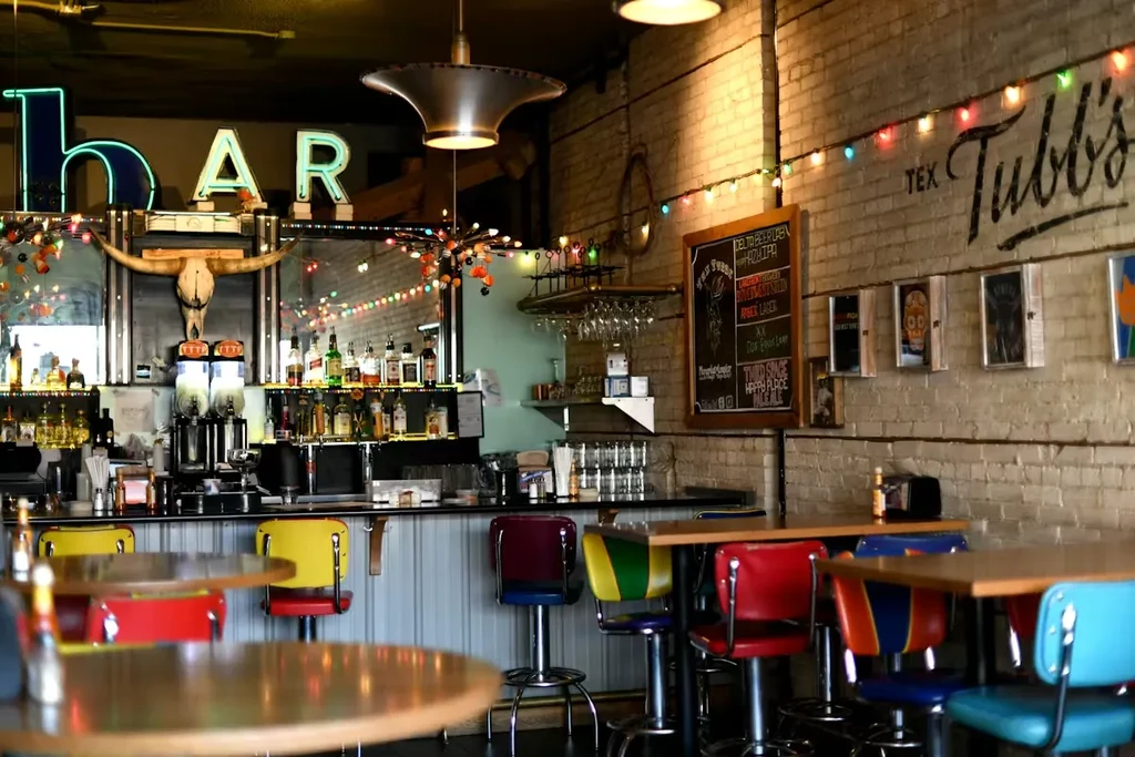 Empty Tex Tubb's bar interior featuring a counter and colorful stools.
