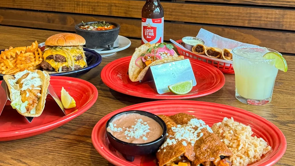 Vibrant overhead view of Tex-Mex dishes and drinks on a wooden table.