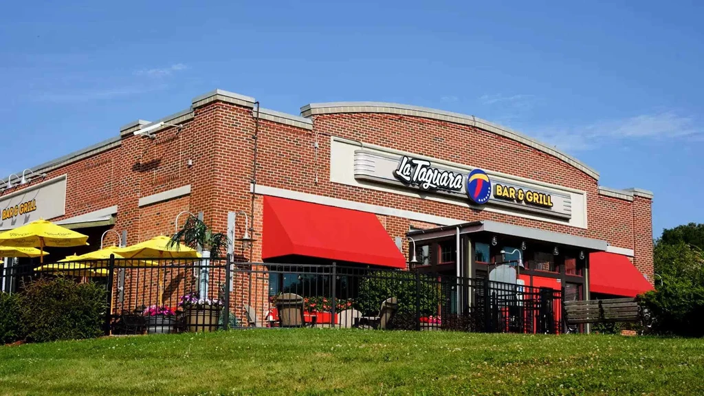 La Taguara Bar & Grill brick building with red awnings and patio.