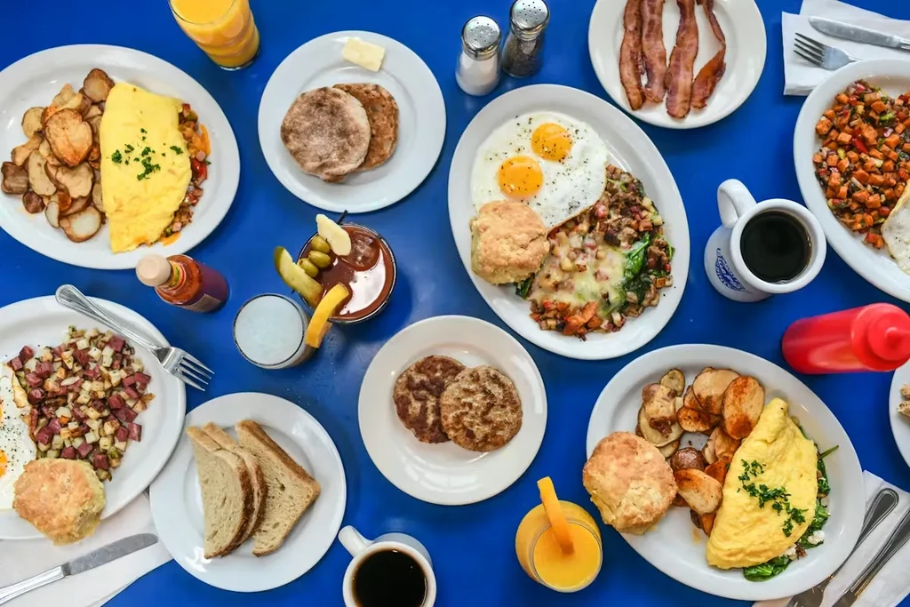 Extensive breakfast and brunch on a blue table with drinks.
