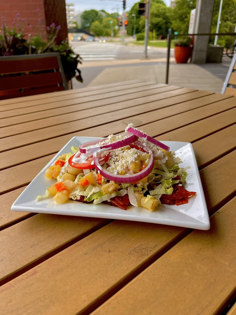 Colorful dish with vegetables and sauce on an outdoor patio table.