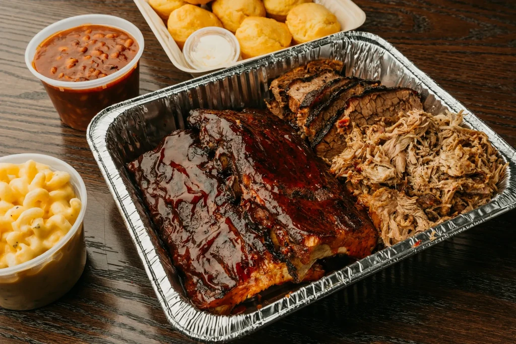 A generous spread of barbecue with ribs, brisket, pulled pork, and sides.